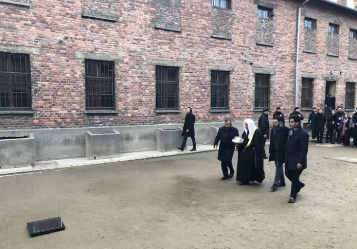 Lors de la visite au Musée d'Auschwitz avec des membres d'AJCGlobal Mohammad Alissa allume une bougie au Mur des Exécutions en mémoire des personnes exécutées.